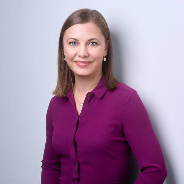 Brunette woman in a green shirt (Elina Kaura, member of the Executive Management Team of Assemblin Caverion Group)