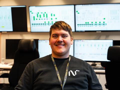 A white collar employee sitting in front of screens
